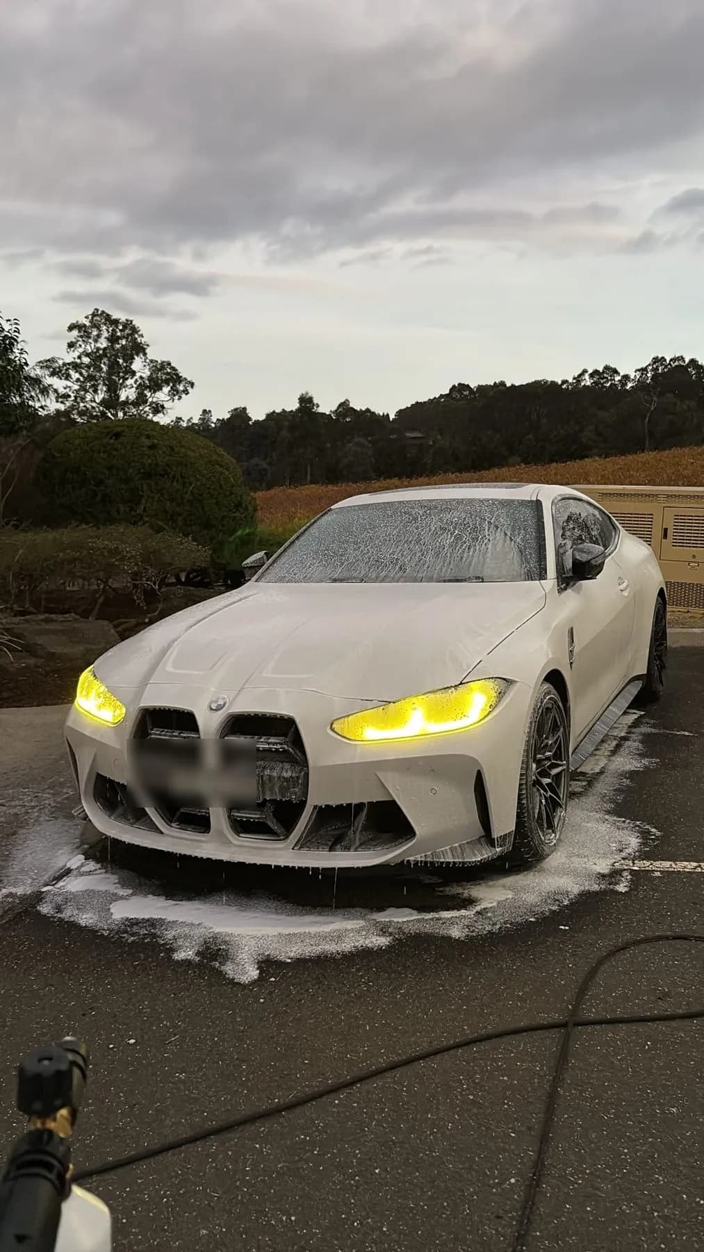 A BMW M4 covered in snow foam during a Crystal Clear exterior detail